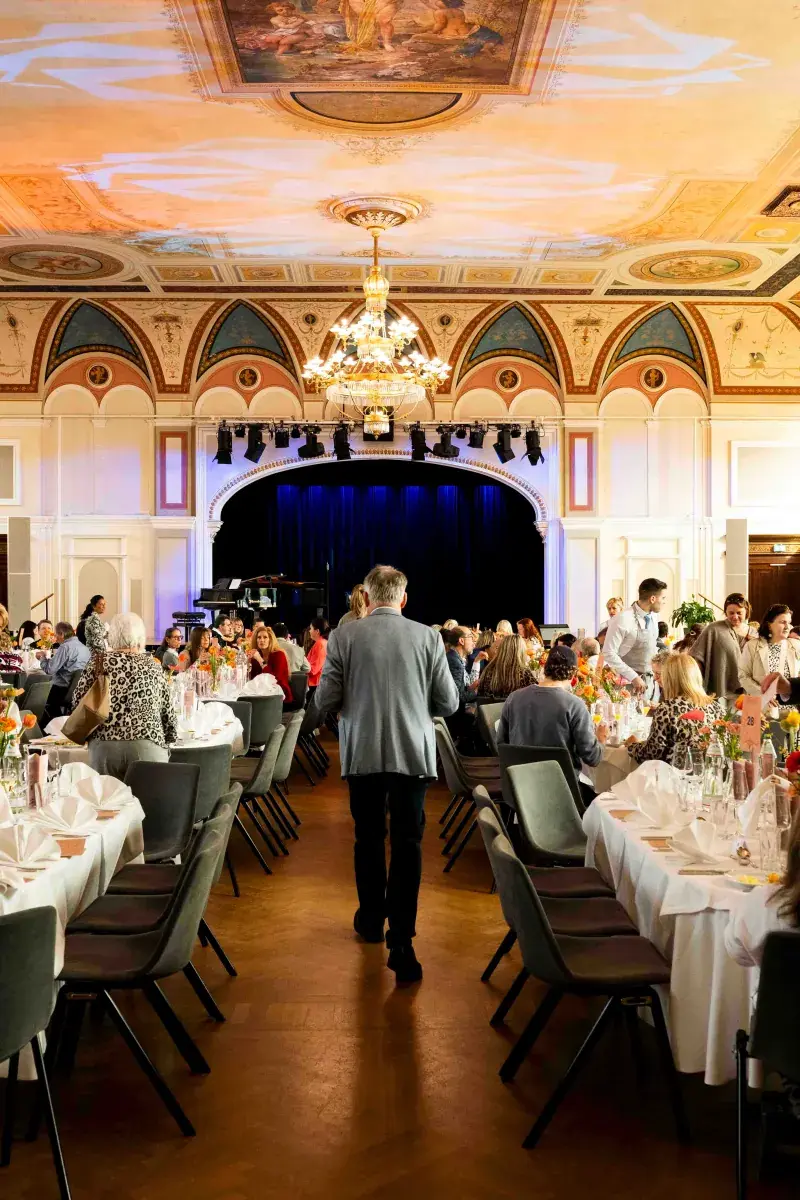 Lange gedeckte Tafeln vor der Bühne im Festsaal des Congress Center Baden